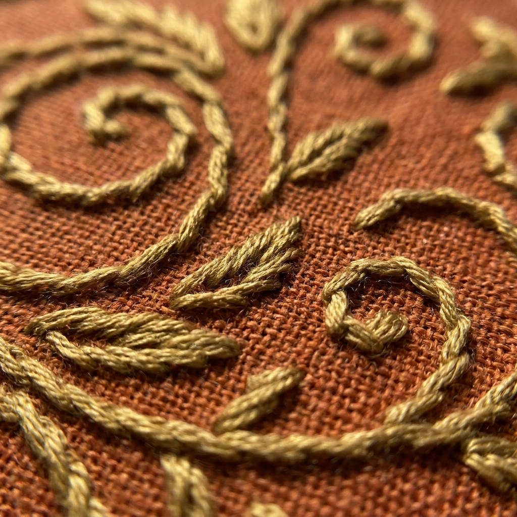 Close-up of hand-worked gold embroidery on linen
