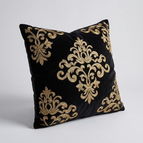 Black velvet pillow cover, angled view showing the raised gold stitching